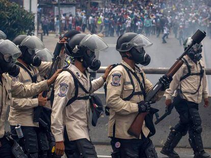 Agentes da Guarda Nacional Bolivariana bloqueiam a passagem de manifestantes em abril.