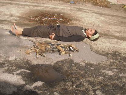 O artista Paulo Nazareth, ao lado do cadáver de um cão.