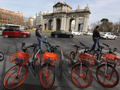 Bicicletas e patinetes elétricos diante da Porta de Alcalá, em Madri.