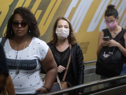 Moradoras de São Paulo usando máscara no metrô.