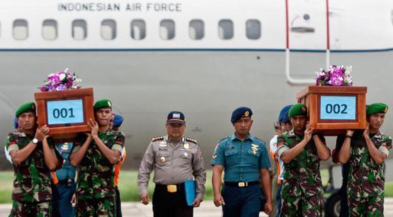 Militares transportam corpos de vítimas do voo QZ8501.