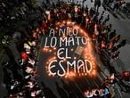 TOPSHOT - Relatives and friends of Nicolas Guerrero, who was killed during clashes with riot police at a protest against a tax reform bill, gather around candles surrounding the words "Nico was killed by ESMAD" ("Escuadron Movil Antidisturbios", a riot control unit of the Colombian police) during a vigil in his honor, in Cali, Colombia, on May 3, 2021. - Protesters in Colombia on May 3 called for a new mass rally after 19 people died and more than 800 were wounded in clashes during five days of demonstrations against a proposed government tax reform. Faced with the unrest, the government of President Ivan Duque on May 2 ordered the tax reform proposal be withdrawn from Congress, where it was being debated. (Photo by Luis ROBAYO / AFP)