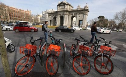 Bicicletas e patinetes elétricos diante da Porta de Alcalá, em Madri.