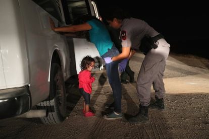 Menina hondurenha chora enquanto sua mãe é revistada pela patrulha fronteiriça em McAllen (Texas), em 2018.