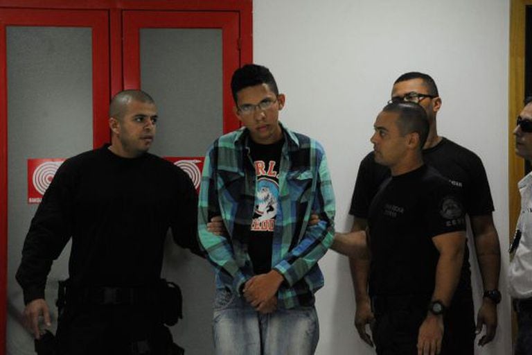 O suspeito Caio Silva de Souza (centro) na sede da polícia do Rio.