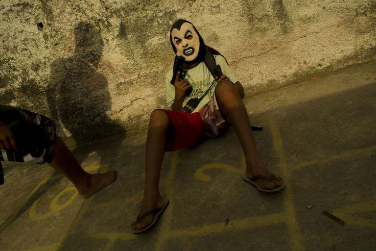 Menino armado trabalha para o tráfico de drogas.