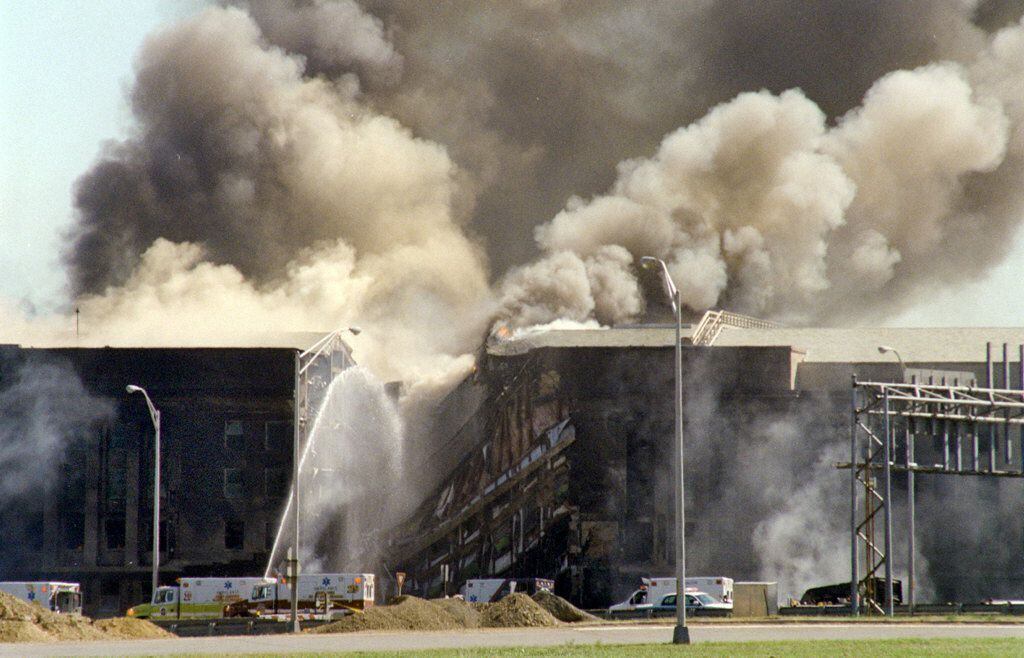 Bombeiros apagam incêndio no Pentágono depois do impacto de um dos aviões do 11/9. 