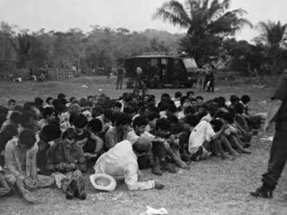 Posseiros rendidos reunidos no campo de futebol do acampamento.