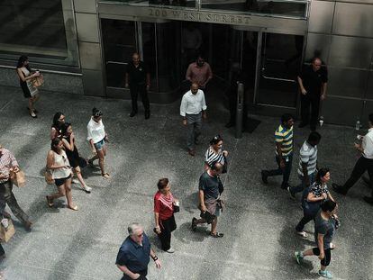 Várias pessoas passam em frente à sede do banco Goldman Sachs, em Nova York.