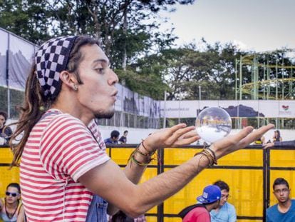 Um jovem faz malabarismo com uma esfera de cristal no Festival Altavoz de Medellín.