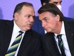 Brazilian President Jair Bolsonaro (R) listens to his Health Minister Eduardo Pazuello, during the launch of the  national vaccination plan against the novel coronavirus Covid-19 at Planalto Palace in Brasilia, on December 16, 2020. - The government has not released a date for the start of the vaccination but commits to start the process 5 days after the approval of a vaccine by the health agency (ANVISA) and expects to take 12 to 16 months to vaccinate the entire Brazilian population. (Photo by EVARISTO SA / AFP)