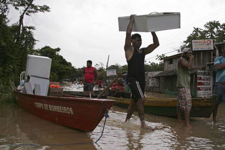 Moradores e a Defesa Civil do Acre tentar salvar seus pertences.