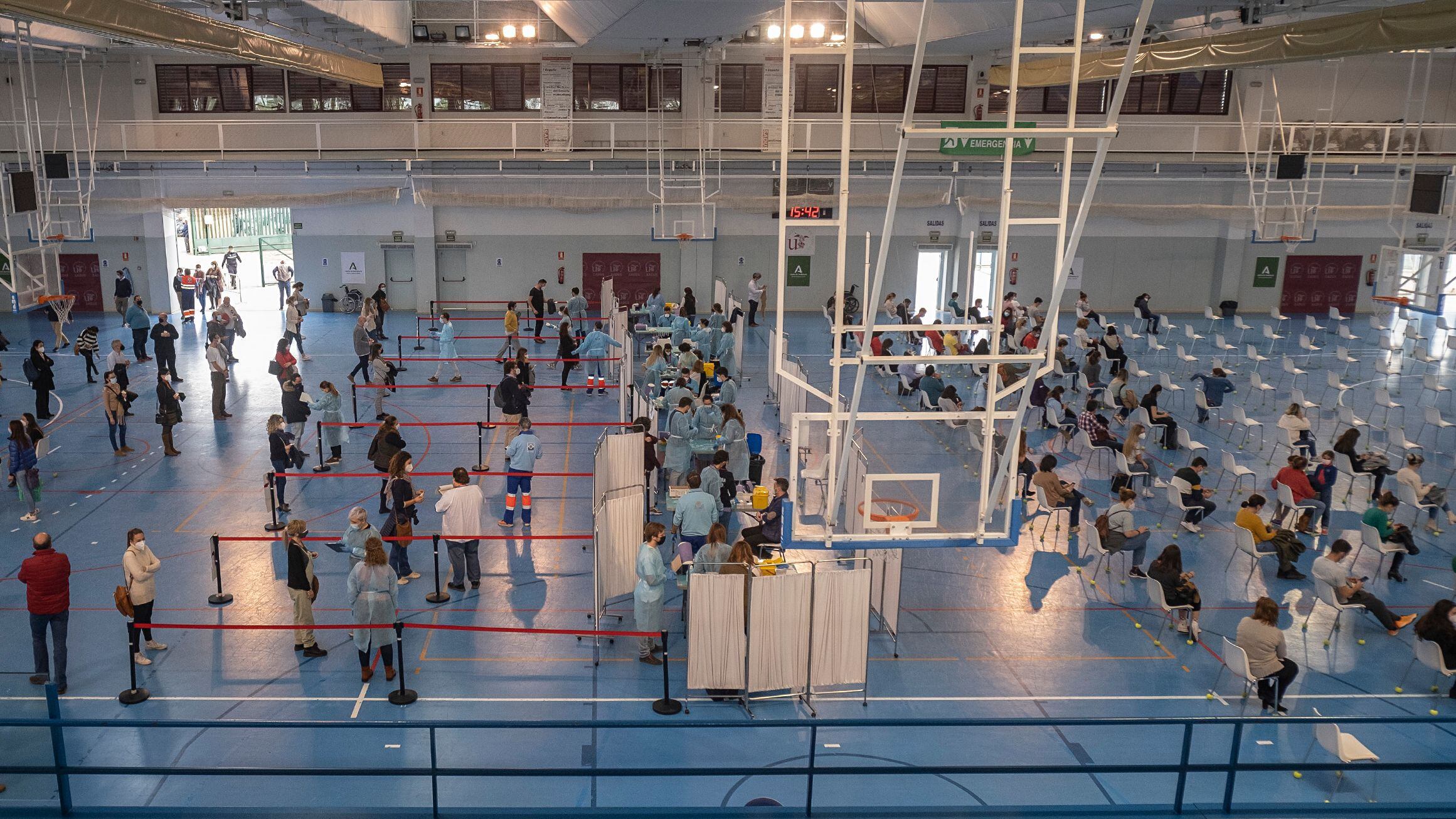 Trabalhadores da Saúde administram a vacina da AstraZeneca no ginásio de esportes da Universidade de Sevilha.