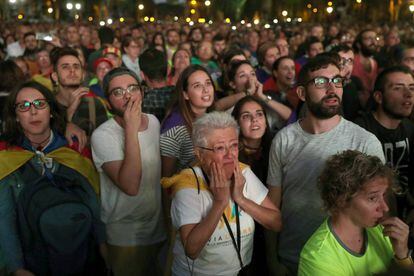 Manifestantes pró-independência acompanham o discurso de Puigdemont do lado de fora do Parlamento da Catalunha.