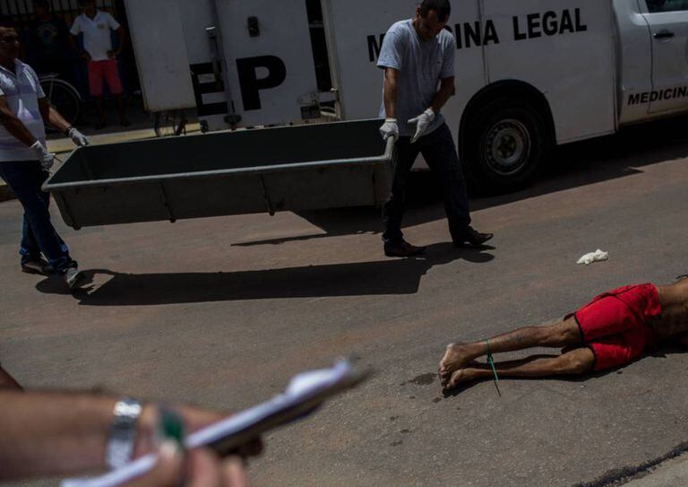 Policiais recolhem o corpo de um homem assassinado num sábado de abril em Natal (RN).