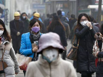 Mulheres vestem máscaras em Pequim.