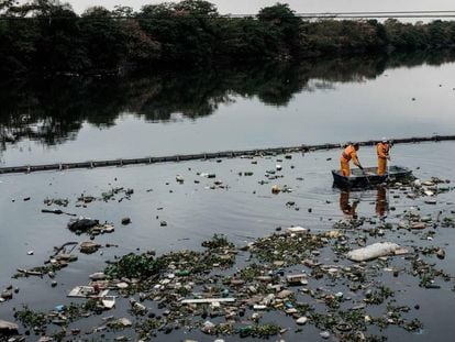 O eco-barcos recolhem os vertidos que se têm colado pela barreira na baía de Guanabara.
