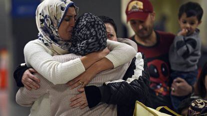 Uma família iraquiana recebe uma mulher que não podia viajar por conta do veto, no domingo no aeroporto de Dulles, Virgínia.