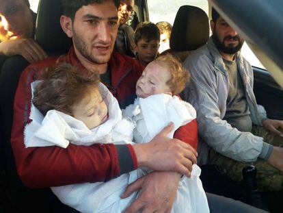 Hassan Youssef,, com os cadáveres de seus dois filhos mortos no ataque de gás tóxico na Síria.
