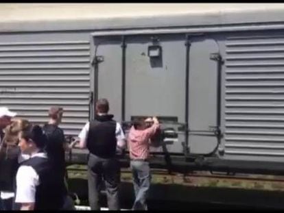 Inspetores da OSCE e legistas holandeses perto do trem onde estão os cadáveres.