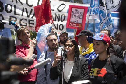 A chanceler da Venezuela, Delcy Rodríguez, fala em Buenos Aires na frente do Ministério das Relações Exteriores rodeada por manifestantes.