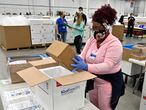 An employee with the McKesson Corporation packs a box of the Johnson and Johnson COVID-19 vaccine into a cooler for shipping from their facility in Shepherdsville, Ky., Monday, March 1, 2021. (AP Photo/Timothy D. Easley, Pool)