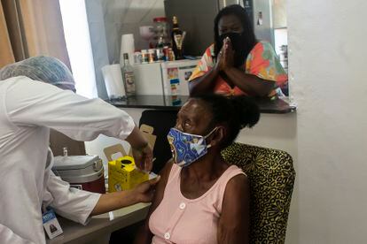 Geralda Olímpio, de 83 anos, recebe vacina contra a covid-19 em sua casa, no Rio de Janeiro.