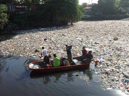 Um grupo de cidadãos retira plásticos de um rio nas Filipinas