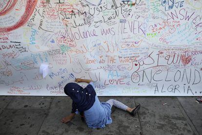Uma criança escreve no muro junto à mesquita.
