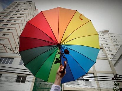 Manifestante defende bandeira LGBT, em frente a um colégio eleitoral de São Paulo