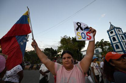 Mulher segura a bandeira da Venezuela em um protesto contra a morte em um naufrágio de migrantes venezuelanos em 17 de dezembro.