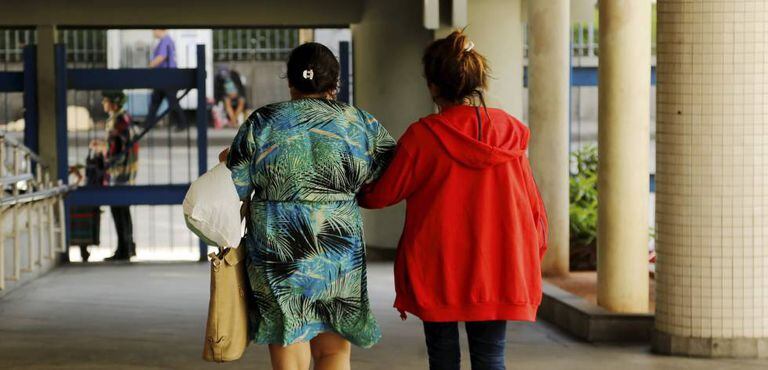 Menor que foi vítima de estupro coletivo deixa o Hospital Souza Aguiar, acompanhada da mãe.