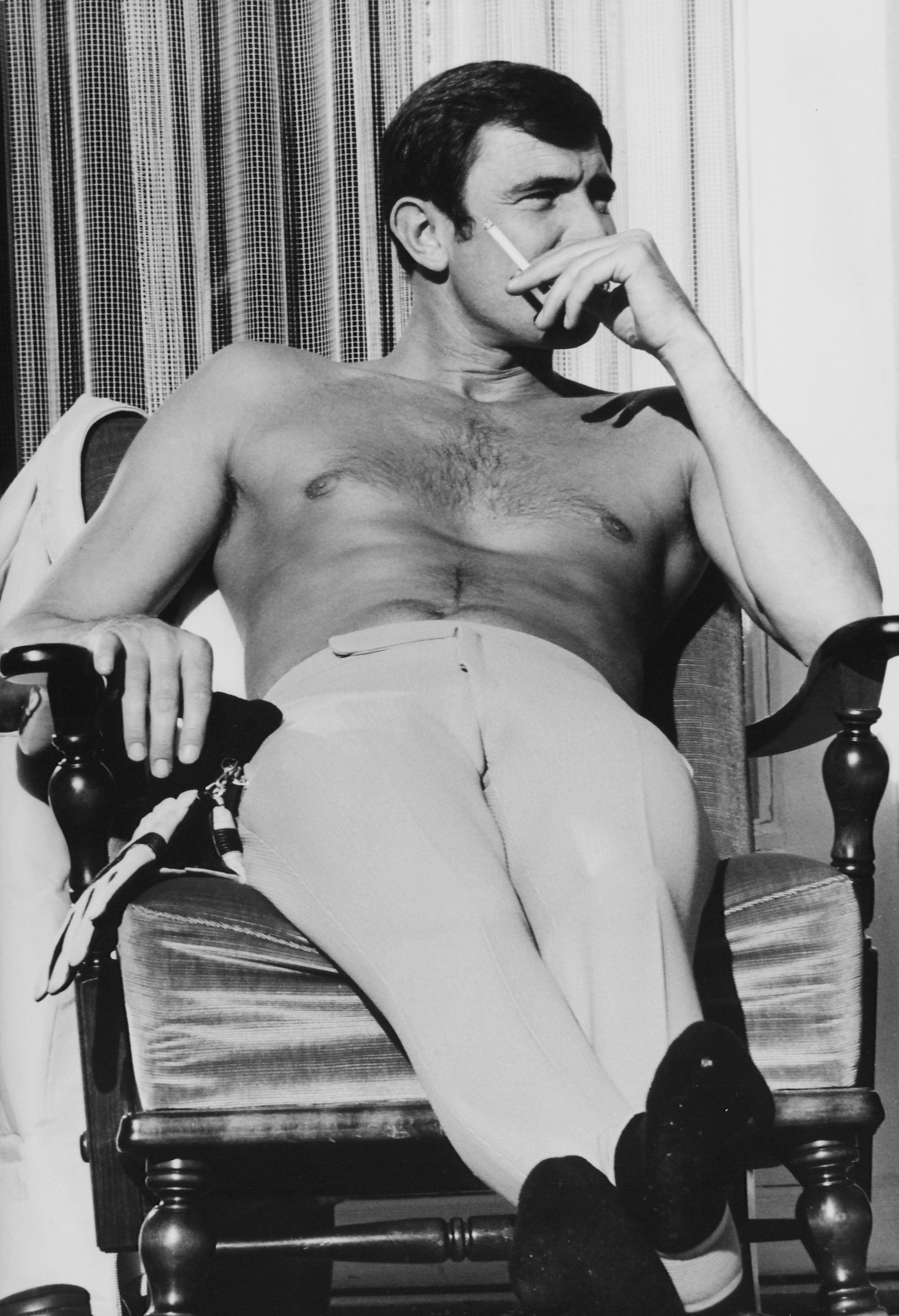 George Lazenby fuma um cigarro durante um descanso nas filmagens de ‘A Serviço Secreto de Sua Majestade’, em 1969.