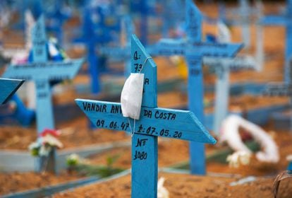 Uma máscara facial é colocada em uma cruz em uma área reservada para o sepultamento das vítimas da Covid-19 no cemitério Nossa Senhora Aparecida em Manaus.