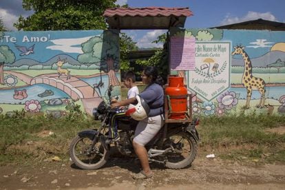 Maribel com o filho em sua motocicleta durante seu dia de trabalho vendendo gás.