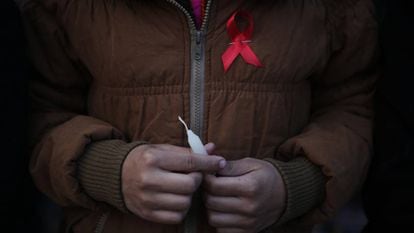 Mulher carrega o símbolo da luta contra a AIDS no mundo, em um centro de reabilitação de vítimas de tráfico sexual no Nepal.