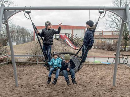 Crianças refugiadas, na balança do pátio de um colégio em Halmstad, Suécia.