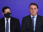 Brazilian President Jair Bolsonaro (R) gestures next to his Vice-President Hamilton Mourao during the launch of the Alliance for Volunteering aid program at Planalto Palace in Brasilia, on November 9, 2020, amid the new coronavirus pandemic. - Bolsonaro, even after 48 hours of confirmation of Joe Biden's victory in the US election, remains without making any comment on the issue. (Photo by EVARISTO SA / AFP)