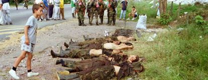 Uma criança olha os cadáveres de guerrilheiros das FARC, no ano 2000.