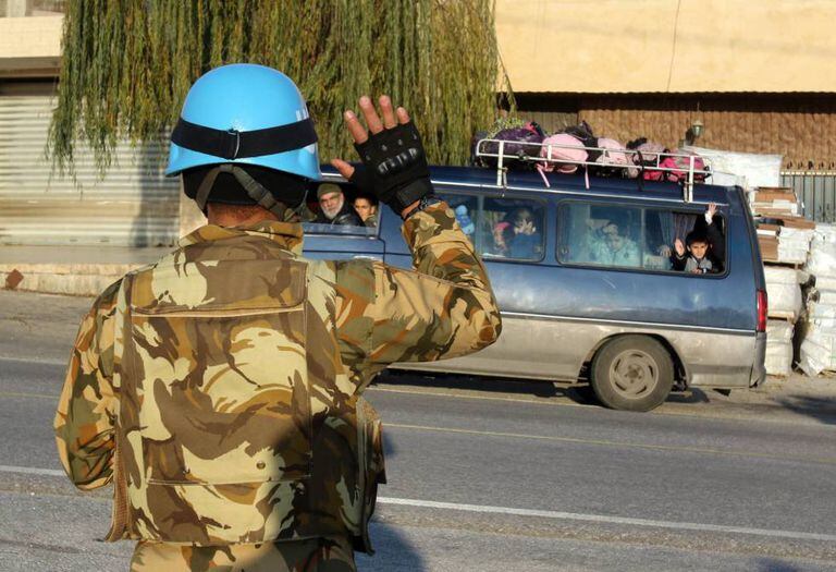 Soldado da Unifil cumprimenta ônibus escolar em Adaisseh, sul do Líbano, em dezembro.