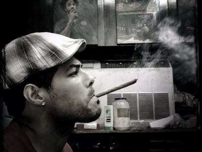 Um homem fuma um charuto na loja de cigarros 'Dominicon' em Manhattan, dia 18 de março de 2014.