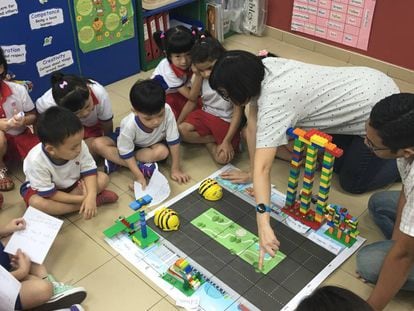Crianças de quatro anos brincam com o BeeBot, abelha-robô usada no ensino de programação, em Cingapura.