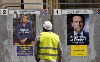 Operário observa cartazes dos candidatos do segundo turno na França.