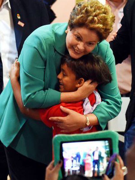 Dilma Rousseff abraça garoto em evento com trabalhadores rurais.