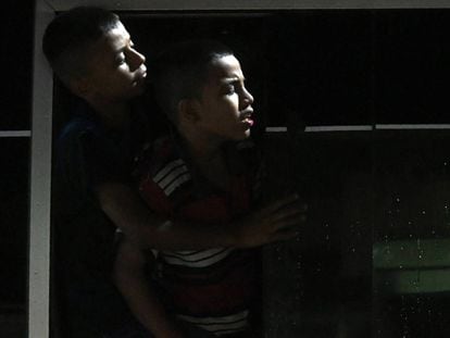 Dois garotos hondureños olham pela janela de um ônibus que abandona San Pedro Sula, e que viaja para a fronteira de Guatemala.