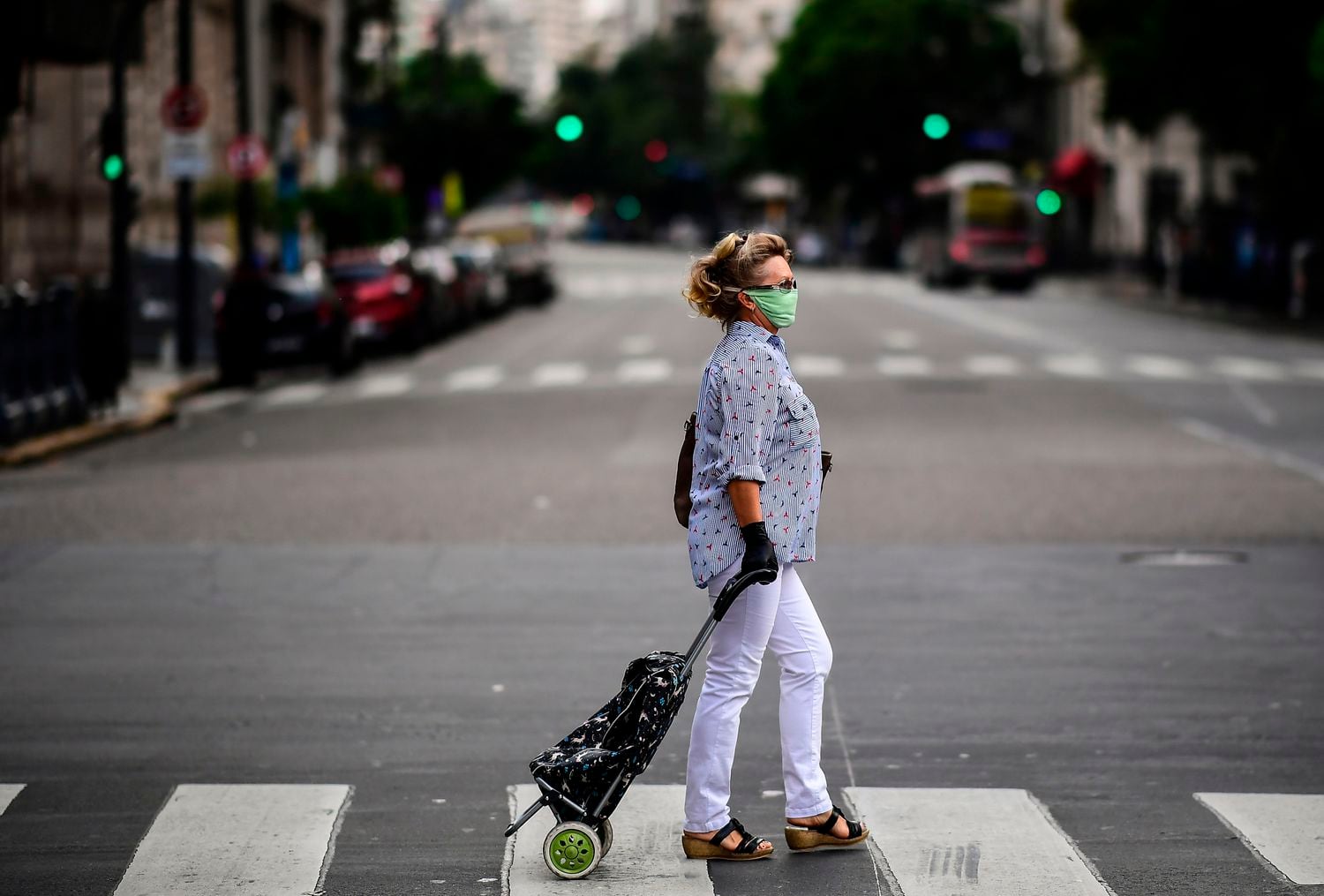 Uma mulher caminha nesta segunda-feira pela avenida Callao, em Buenos Aires, geralmente movimentada, esvaziada pelas medidas de isolamento social adotadas pela Argentina.
