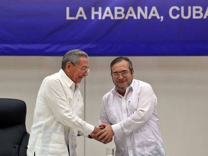 O líder das FARC, Rodrigo Londoño Echeverri, alias "Timochenko" (d), estreita a mão do presidente de Cuba, Raúl Castro.