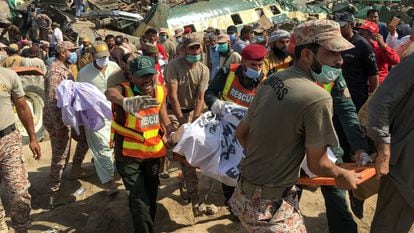 Membros das equipes de resgates sobre o teto de um dos vagões acidentados no choque entre dois trens na província paquistanesa de Sindh, nesta segunda-feira.