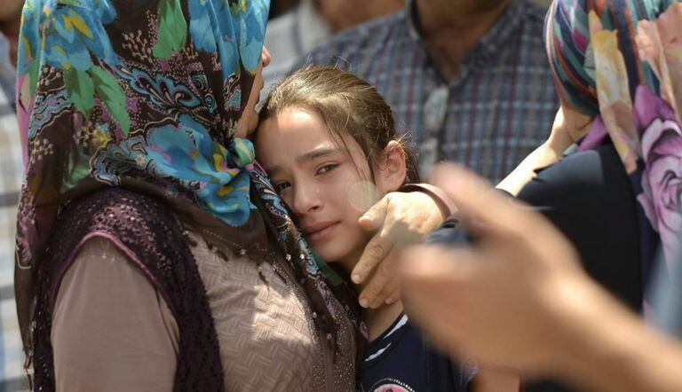 Familiares choram ao identificar vítimas do ataque.