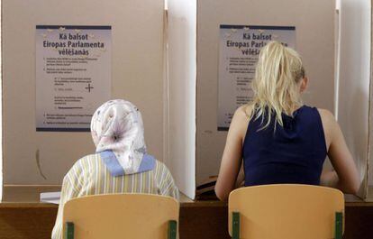 Duas lituanas preenchem suas cédulas para as eleições europeias em Riga.